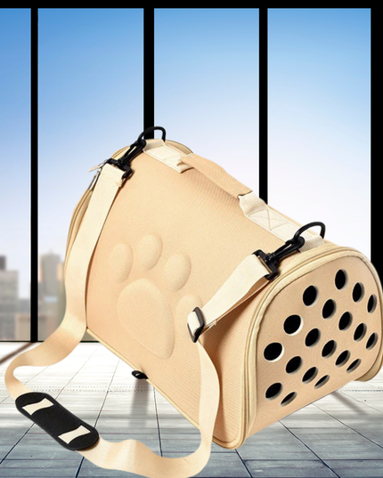 Beige pet carrier with paw print design on a tiled floor with large windows in the background.