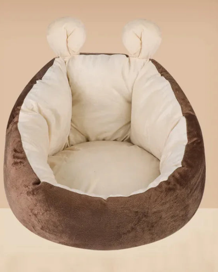 Brown pet bed with white cushion on a beige background