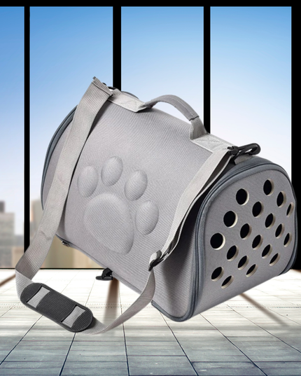 Gray pet carrier with paw print design on a light wooden floor.
