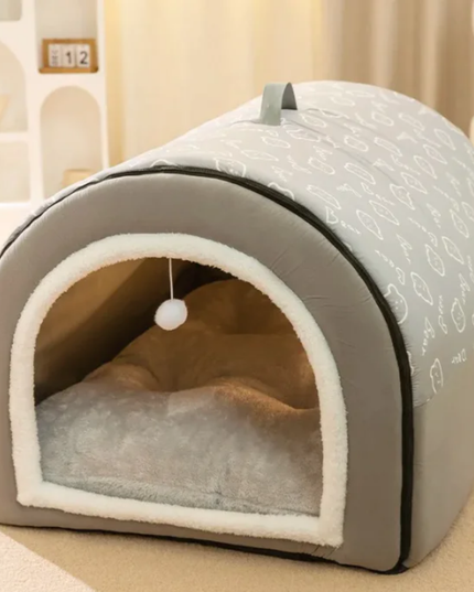 Gray pet bed with white interior on a beige surface