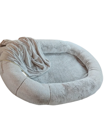 Round pet bed with a soft blanket on a white background