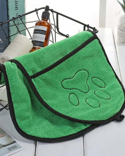 Green towel with paw print design on a white surface
