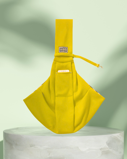 Yellow sling bag on a white pedestal with a light green background