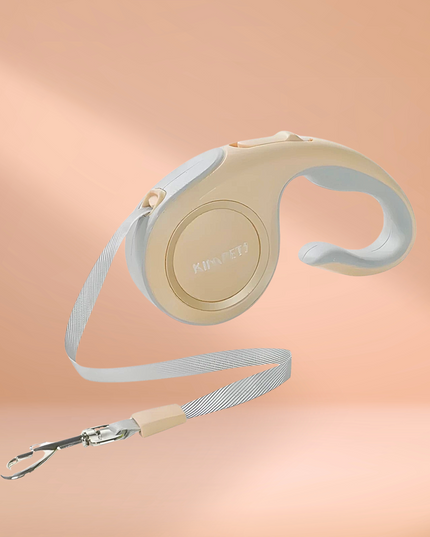 Retractable dog leash with beige handle on a peach background