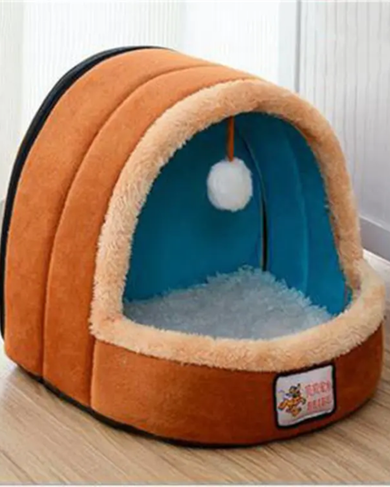 Pet bed with a fluffy interior and a small white ball on a wooden floor.