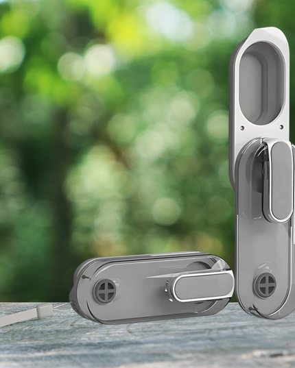Silver door handle set on a wooden surface with a blurred green outdoor background