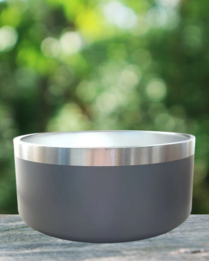 Gray bowl with silver rim on a wooden surface with a blurred green background