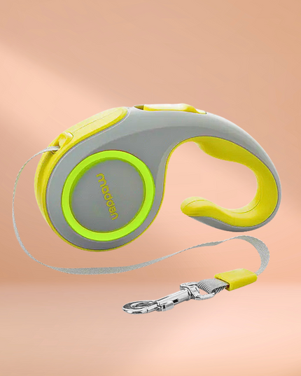 Retractable dog leash with green handle and gray reel on a peach background