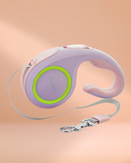 Retractable dog leash with purple handle and green accent on a peach background