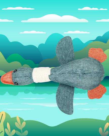 Plush toy duck with orange feet and gray body against a colorful landscape background