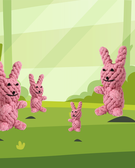 Four pink knitted bunnies in a forest setting with green trees and grass.