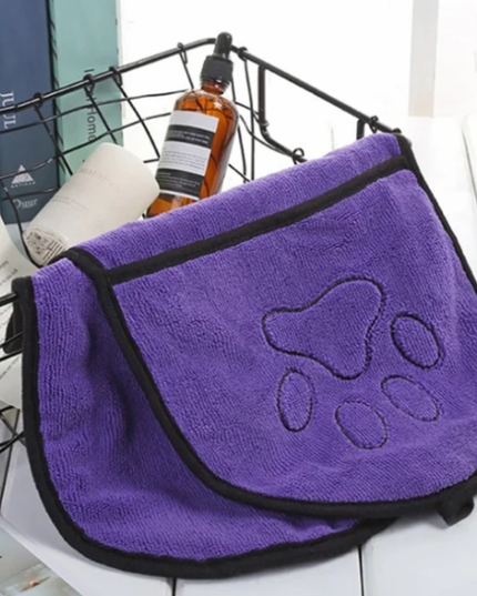 Purple towel with paw print design on a white surface