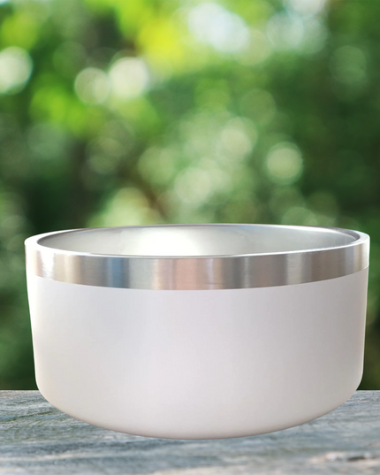 White bowl with silver rim on a wooden surface with a blurred green background