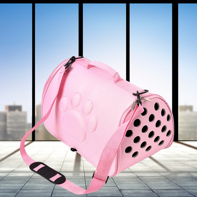 Pink pet carrier with black polka dots on a tiled floor with large windows in the background