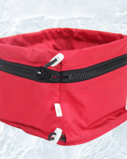 Red pet carrier with a black zipper on a white background