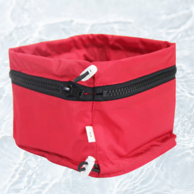 Red pet carrier with a black zipper on a white background