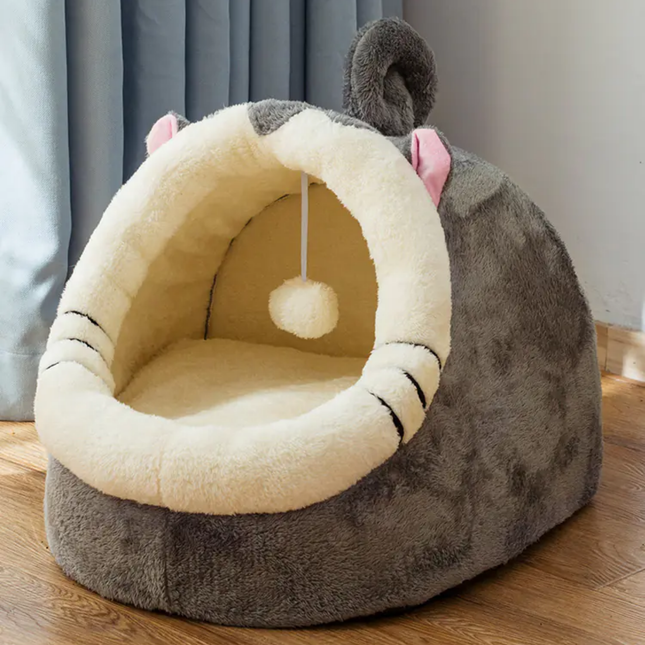 Cat-shaped pet bed with a soft interior on a wooden floor.