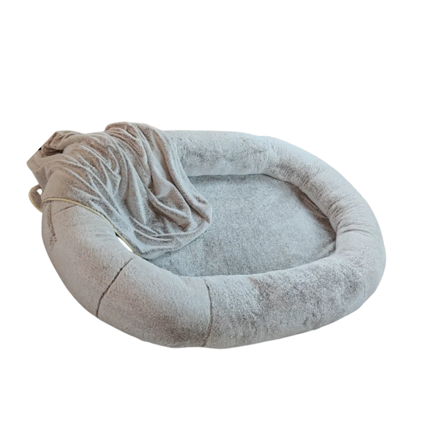 Round pet bed with a soft blanket on a white background