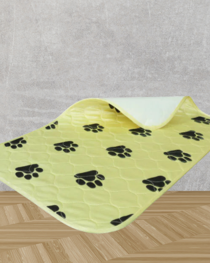 Yellow pet mat with black paw prints on a gray and wooden surface