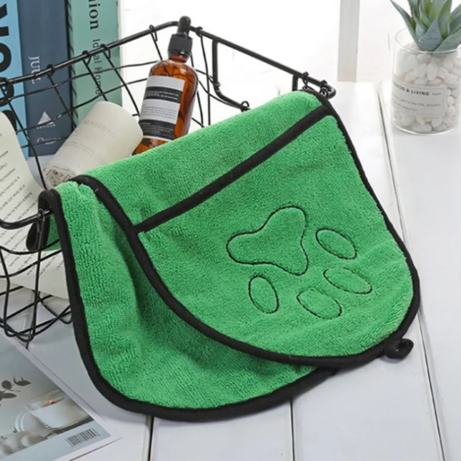Green towel with paw print design on a white surface