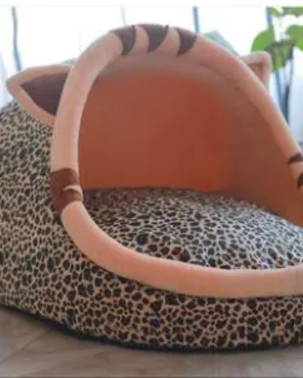 Leopard print pet bed with a plush tiger face on a light background