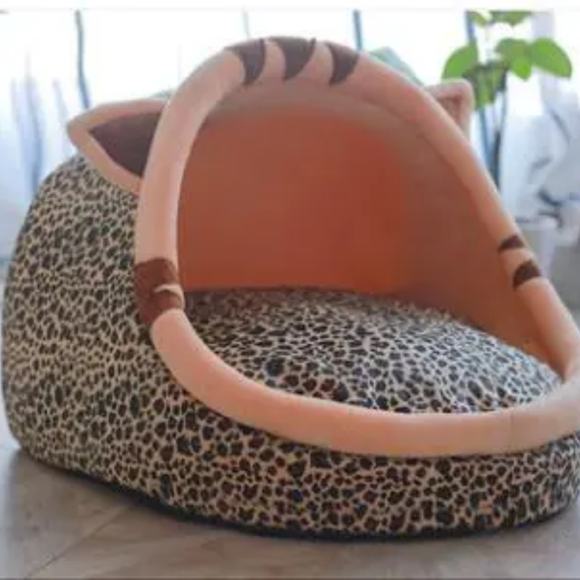Leopard print pet bed with a plush tiger face on a light background