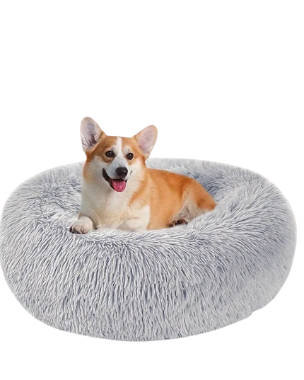 Dog lying on a fluffy gray pet bed against a white background