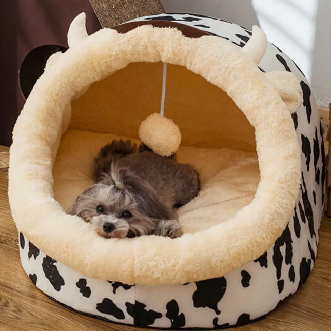 Dog lying in a round pet bed with a cow print base