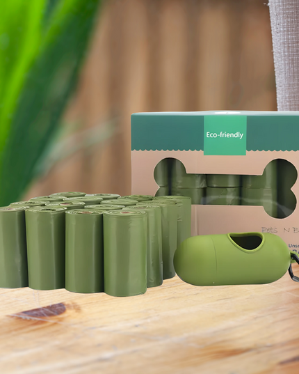 Green eco-friendly dog waste bags with packaging on a wooden surface