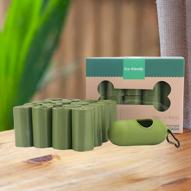 Green eco-friendly dog waste bags with packaging on a wooden surface