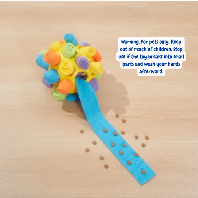 Colorful dog toy with a warning label on a wooden surface