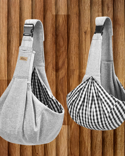 Two gray pet sling bags with checkered lining on a wooden background