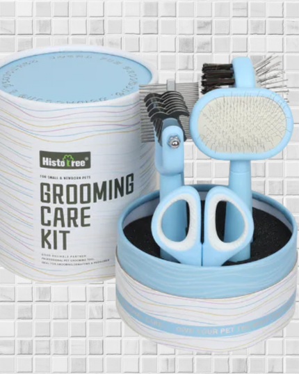 Pet grooming care kit with scissors, brush, and comb in a cylindrical container on a tiled background.