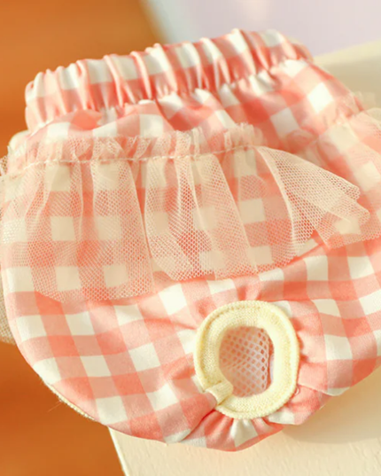Pink and white checkered pet diaper with tulle on a blurred background