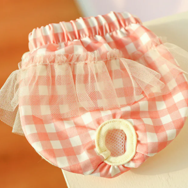 Pink and white checkered pet diaper with tulle on a blurred background