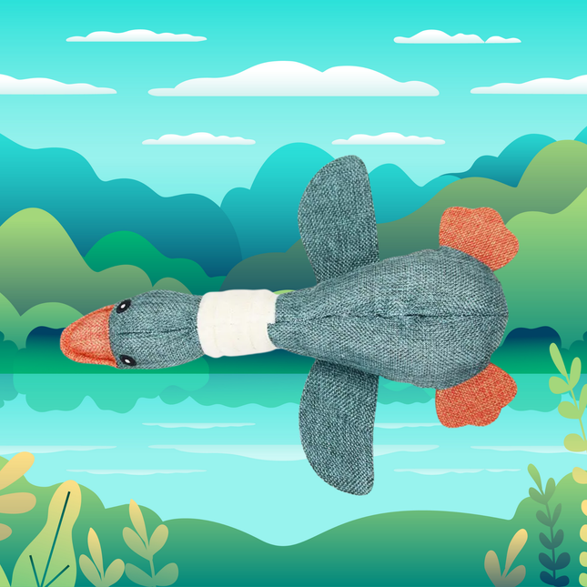 Plush toy duck with orange feet and gray body against a colorful landscape background