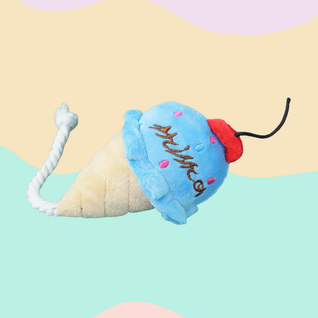 Plush ice cream cone toy with a blue scoop and red cherry on a colorful background