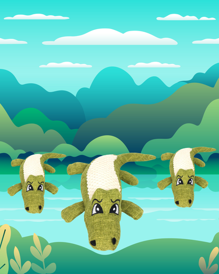 Three green and white toy goats in a forest setting with trees and water in the background.
