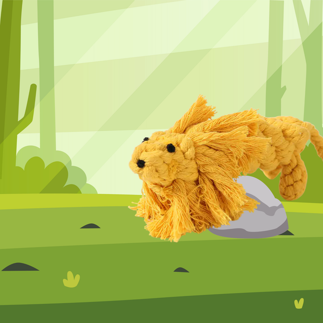 Plush lion toy on a green landscape with trees and rocks
