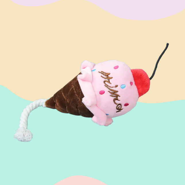 Plush toy shaped like a ice cream cone with a cat on top against a colorful background