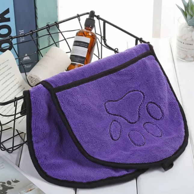 Purple towel with paw print design on a white surface