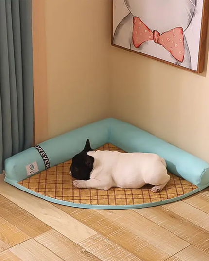 Dog lying on a checkered mat inside a corner pet bed with a cartoon wall decoration.