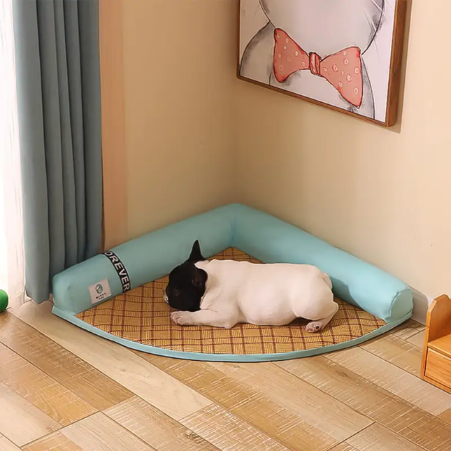 Dog lying on a checkered mat inside a corner pet bed with a cartoon wall decoration.