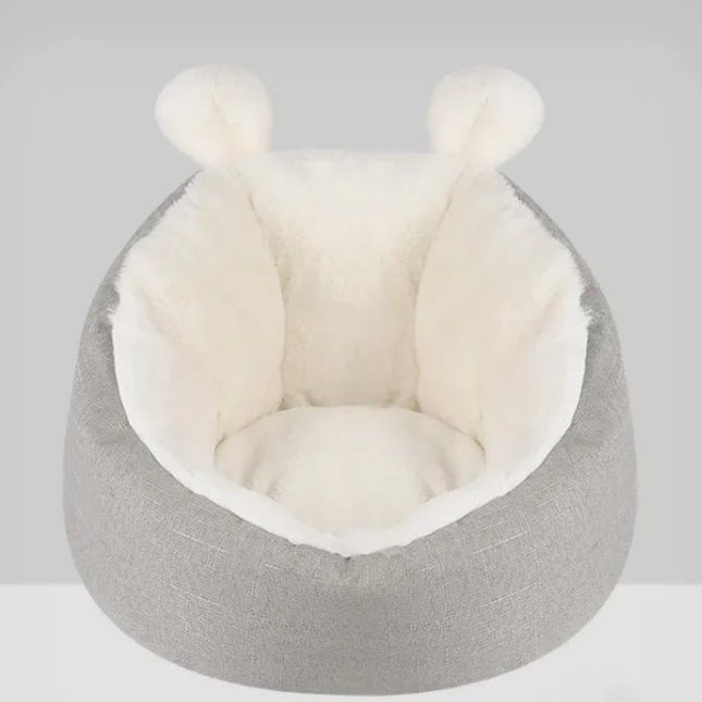 Gray pet bed with white interior on a light gray background