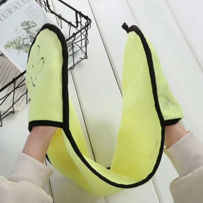 Yellow towel with black trim draped over a person's shoulder, with a magazine in the background.